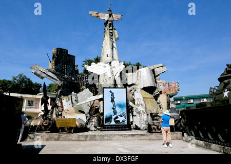 A Tourist looks at the wreckage of captured American planes at the Vietnam military history Museum, Vietnam, South East Asia Stock Photo