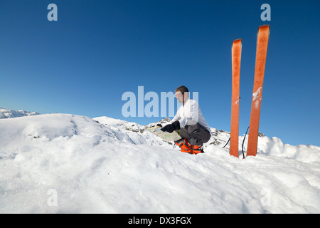 Alpinist watching a map on the summit. Pair of back country ski with sealskin. Stock Photo