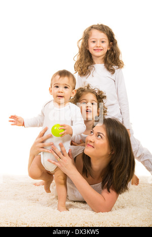 Cheerful family of mother and three kids lying on carpet home Stock Photo