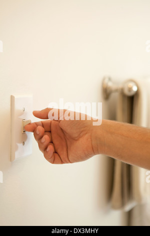 Man's hand turning on light switch, close up Stock Photo