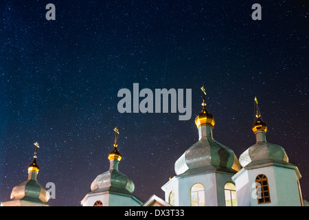 Starry night sky over a Christian church on Easter. Bright stars. Stock Photo
