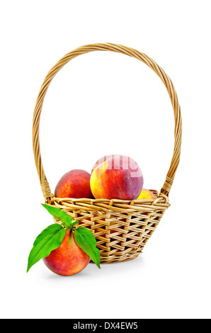 Several whole peaches, green leaves, wicker basket isolated on white background Stock Photo