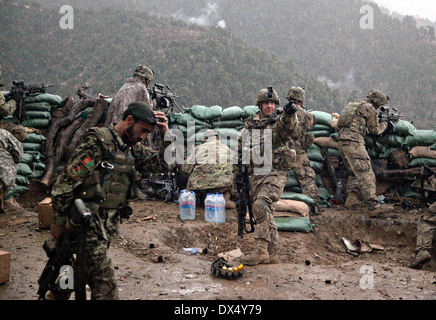 A US Army soldier with the 101st Airborne Division points out incoming rounds during a firefight with the Taliban March 29, 2011 in the valley of Barawala Kalet, Kunar province Afghanistan. Stock Photo