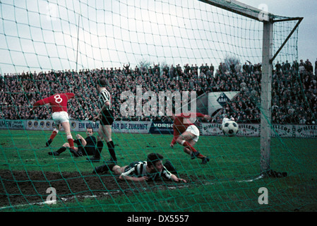 football, Regionalliga West, 1963/1964, Stadium an der Hafenstrasse, Rot Weiss Essen versus VfB Bottrop 7:2, Essen scores a goal, the VfB players f.l.t.r. keeper Rolf Kornas, Guenter Mikolaiczak and Hermann Koopmann are beaten Stock Photo