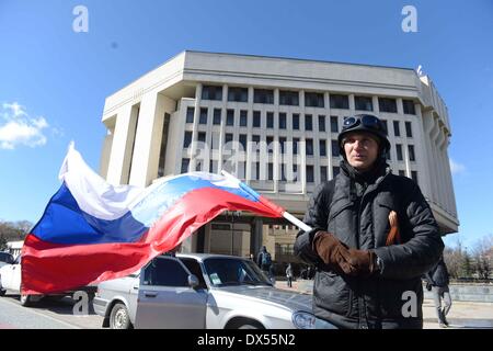 Simferopol. 17th Mar, 2014. File photo taken on March 17, 2014 shows a man waving a national flag of Russia in front of the local parliament in Simferopol, Crimea, Ukraine. Russian President Vladimir Putin signed an agreement on Tuesday accepting the Republic of Crimea and the city of Sevastopol as part of its territory, live TV broadcast showed. Credit:  Sadat/Xinhua/Alamy Live News Stock Photo