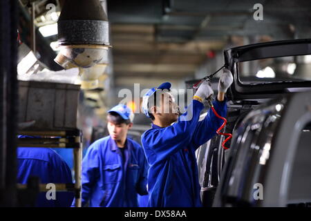 Nanchang, China. 18 March 2014. Workers work on an assembly line in Changhe Automobile Co. in east China's Jiangxi Province, March 12, 2014. In 2013, Beijing Automotive Group (BAIC), China's fifth-largest auto maker by sales, signed an agreement to pay about 80 million yuan (13 million U.S. dollars) for a 70-percent stake in Changhe Auto. The Jiangxi-based automaker expects to expand its yield capacity to 180,000 units in 2014, rising 60 percent year-on-year. © Xinhua/Alamy Live News Stock Photo