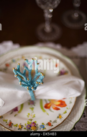 Blue coral napkin ring on floral plate, place setting, high angle view Stock Photo