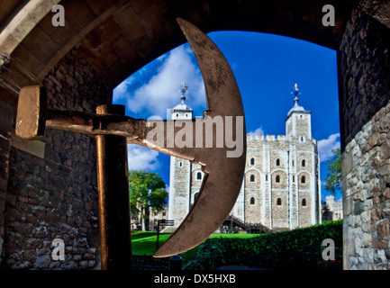 TOWER OF LONDON AXE PRISON Historic axe head and staff with The Tower of London 'White Tower' viewed through stone entrance archway London EC3 UK Stock Photo