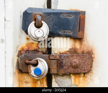 2 rusty round padlocks on an outside building. Stock Photo