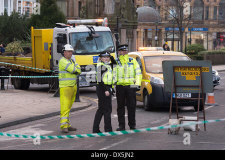 Behind 'no entry' tape, on duty police officers & council worker in h-vis uniforms, stand by 'road closed' sign - Harrogate, North Yorkshire, England, UK. Stock Photo