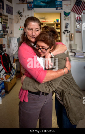 A San Clemente, CA, high school chemistry teacher receives a sympathetic hug from one of her students after the death of her mother. Stock Photo