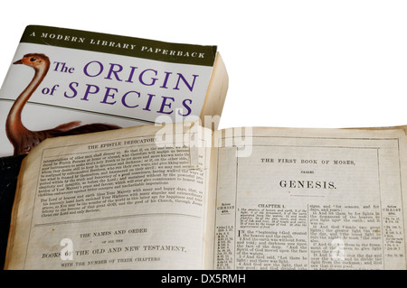 The Origin of Species by Charles Darwin and the bible open at the  book of genesis Stock Photo