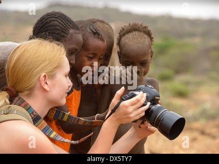 Hamer children and tourist enjoying a photograph near Turmi in the Omo Valley, Ethiopia Stock Photo