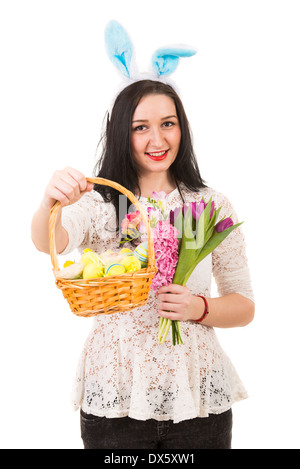 Happy woman with bunny ears giving Easter basket and holding spring flowers isolated on white background Stock Photo