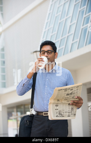 indian business man with coffee and papers outside his office Stock Photo