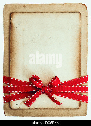 vintage card with red ribbon bow isolated on white background. grunge paper Stock Photo