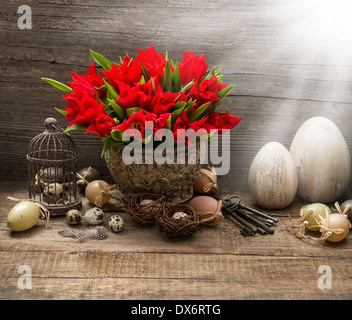 vintage easter composition with eggs and red tulips. nostalgic still life home interior with light beams