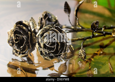 Three pretty shiny Golden rose, forged from metal. Manual work. Stock Photo