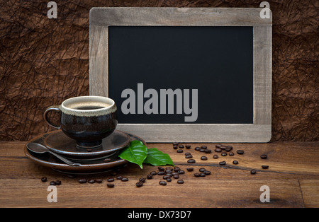 cup of coffee and antique blackboard. coffee leaves and beans. retro style image Stock Photo
