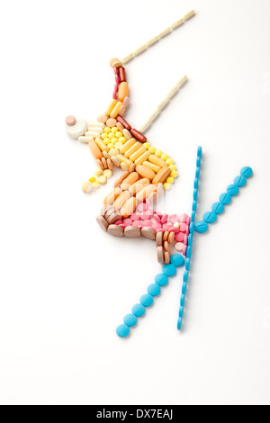 Doping pills and drugs in the shape of a winter jumping skier. Stock Photo