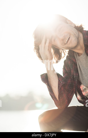 A happy healthy young male by the waterside on a sunny afternoon Stock Photo