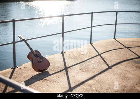 An acoustic guitar on a jetty by the sea Stock Photo