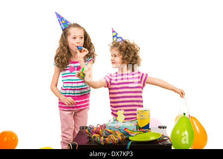 Little girls sisters at birthday party with cake and balloons against white background Stock Photo