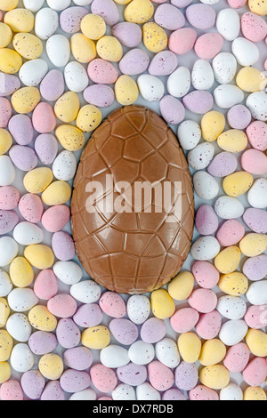 A chocolate Easter egg surrounded by candy covered mini eggs