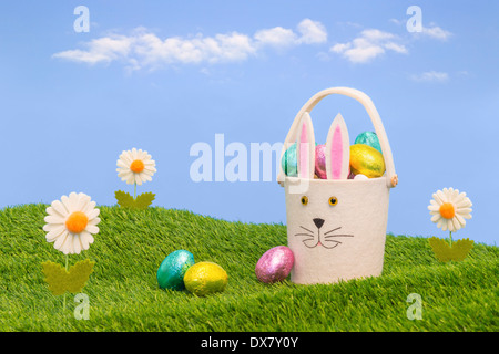 Easter basket full of foil wrapped chocolate eggs. Stock Photo