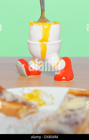 Boiled egg and toast breakfast with a spoon making the yolk run. Stock Photo