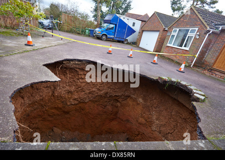 General view of a 30 ft deep sinkhole, with a car at the bottom, outside a family house in Walter's Ash, near High Wycombe Stock Photo
