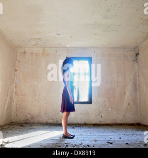 Woman standing by the window Stock Photo