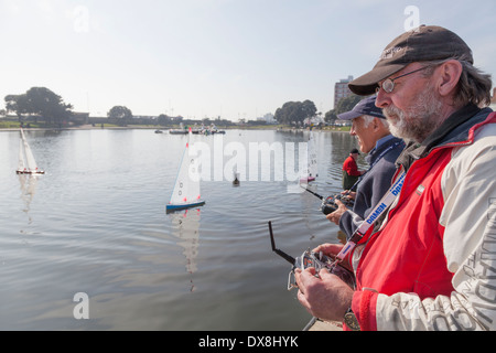 Radio controlled model yacht enthusiasts racing on Canoe Lake Southsea. Stock Photo