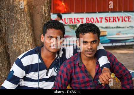 South Southern India Kerala Fort Cochin Kochi quayside 2 two young men males fishermen pose posing on quayside Stock Photo