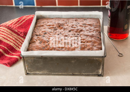 making a traditional rich fruit cake, square cake cooked/baked ready to take out of baking tin to cool(3 of series of 8) Stock Photo