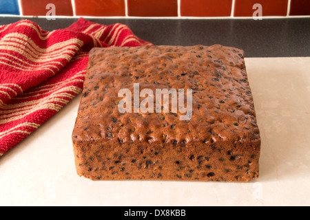 traditional rich fruit cake removed from baking tin placed on cream marble worktop [land] (5 of a series of 8) Stock Photo