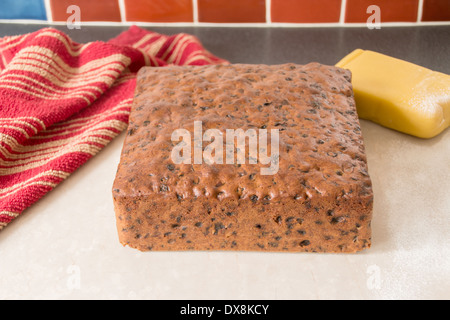 making rich fruit cake, square cake ready to ice  removed from tin placed on cream marble worktop (6 of series of 8) Stock Photo