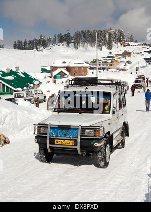 India, Kashmir, Gulmarg, Himalayan Ski Resort main bazaar, share taxi with chains on wheels in snow Stock Photo