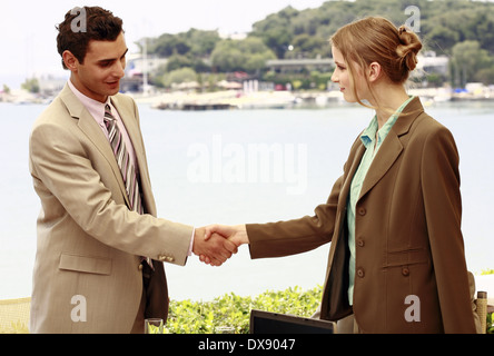 Man and woman shaking hands at seaside meeting Stock Photo