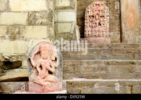 Religious stone slabs with hindu deities and red-dyed by the offerings from the faithfuls. Gorakhnath-Gorkha Durbar-Nepal. Stock Photo