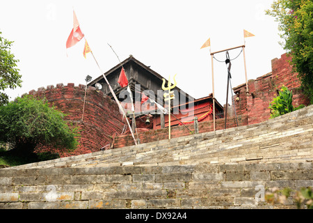 Nepali flags and Shiva's trident on the stairs connecting the Gorakhnath cave-temple with the Gorkha Durbar. Nepal. Stock Photo