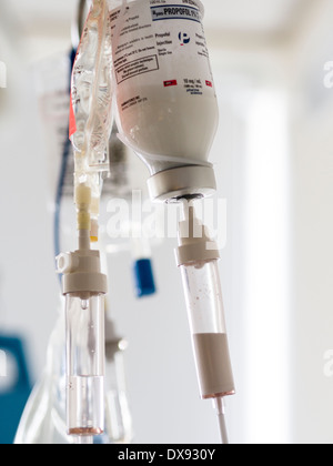 Bottle of Propofol Intravenous Drip. A bottle of propofol 1% and another intravenous bag drips in a hospital ICU room. Stock Photo