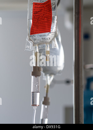 Intravenous drip bag hangs in a hospital room feeding saline solution ...