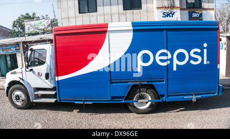 brightly painted red white & blue pepsi cola soda truck makes a delivery in small town by side of highway Valley of Oaxaca Stock Photo