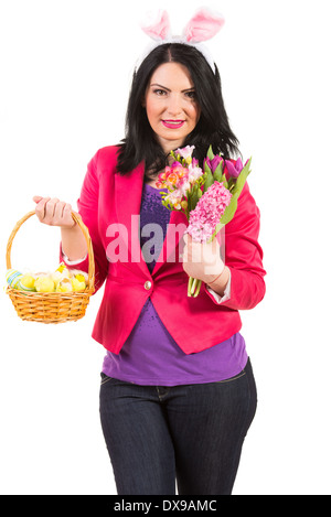 Beauty spring woman with bunny ears holding Easter basket and flowers Stock Photo