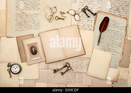 open book, vintage accessories, old letters, post cards, glasses, keys, clock. nostalgic background Stock Photo