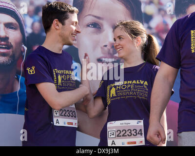 Jerusalem, Israel. 21st Mar, 2014. GILAD SHALIT, IDF soldier abducted by Hamas in Gaza in 2006 and released in 2011 as part of a prisoner exchange deal, and girlfriend, share an intimate moment as they prepare to run for Team Shalva, the Association for Physically & Mentally Challenged Children in Israel. Thousands ran in a special 800 meter 'Social Track' in the framework of the Jerusalem 2014 International Marathon for communities with special needs. Credit:  Nir Alon/Alamy Live News Stock Photo