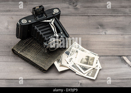 vintage photo camera and album with old photos on wooden table. memories Stock Photo