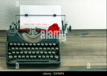 vintage typewriter with love letter and red rose flower. sample text Each day with you... Stock Photo