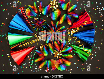 carnival party decoration. colorful garlands, streamer, hats and confetti on black background Stock Photo